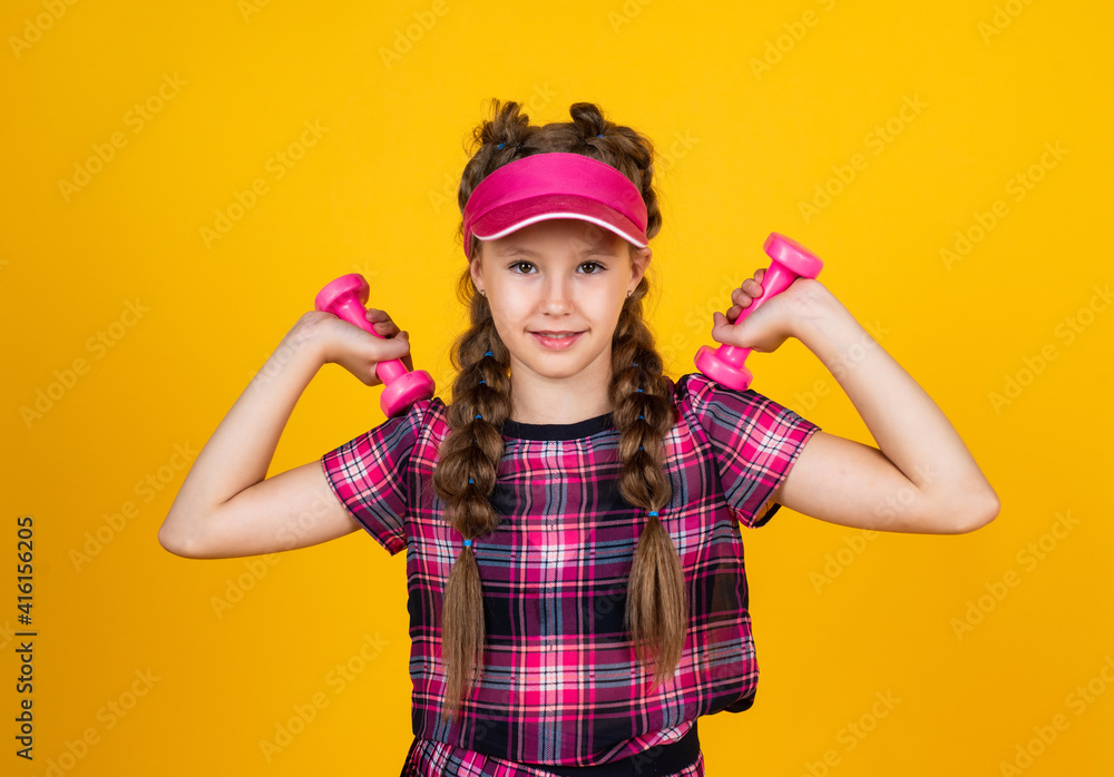 Be strong. teen girl training. dedicated to fitness. sport tools and equipment. healthy and active lifestyle. full of energy. happy childhood. kid in cap hold barbells. child with dumbbells Be strong. teen girl training. dedicated to fitness. sport tools and equipment. healthy and active lifestyle. full of energy. happy childhood. kid in cap hold barbells. child with dumbbells