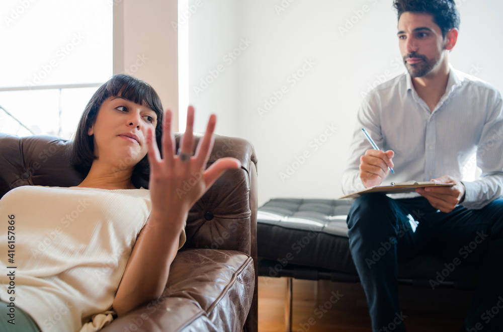 Psychologist taking notes during therapy session. Psychologist taking notes during therapy session.