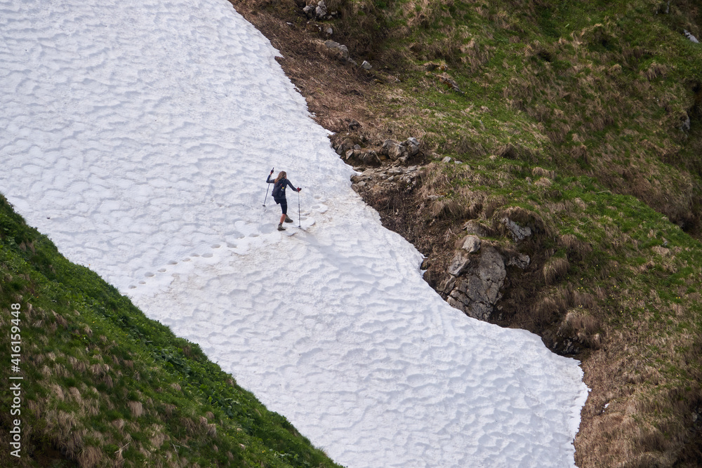 Bergwanderer überquert ein steiles Schneefeld