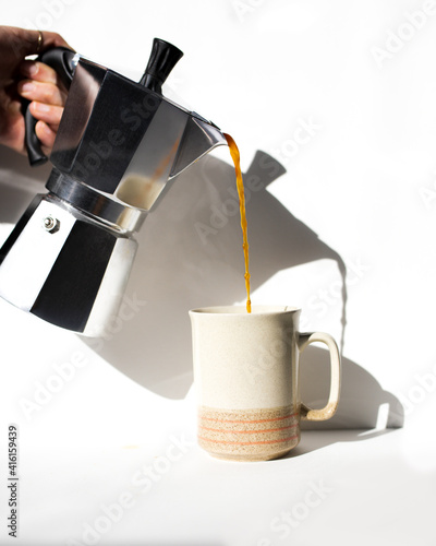 Person pouring coffee into mug