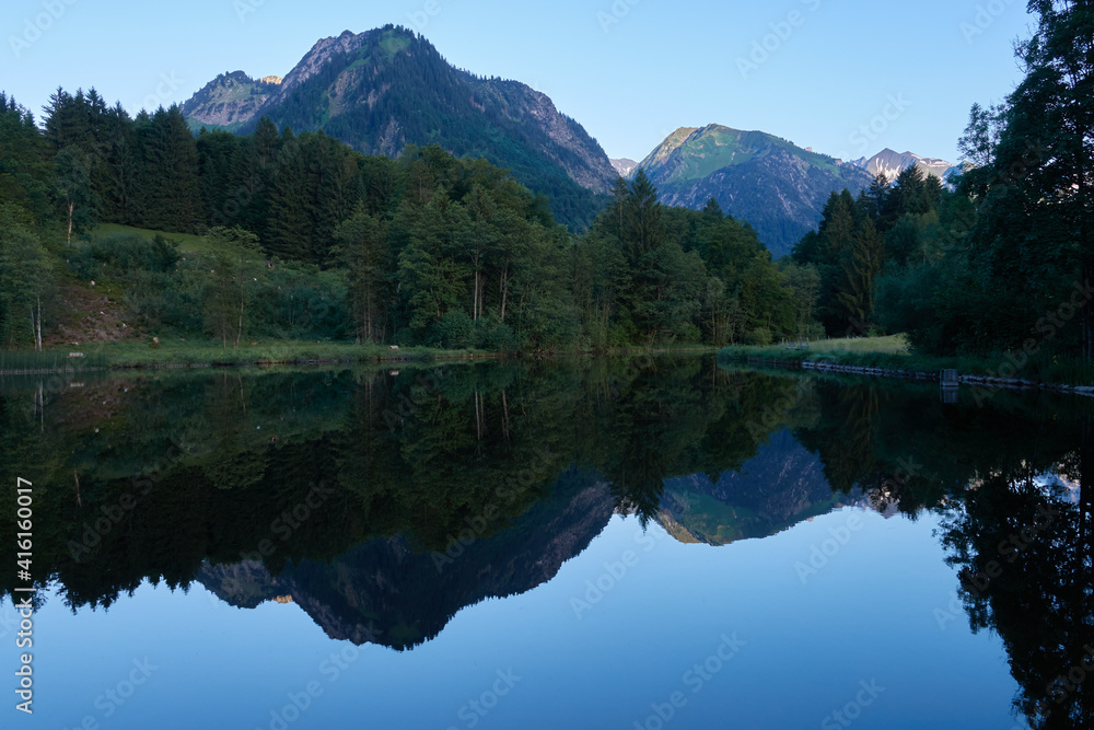 Spiegelungen im Bergsee am frühen Morgen