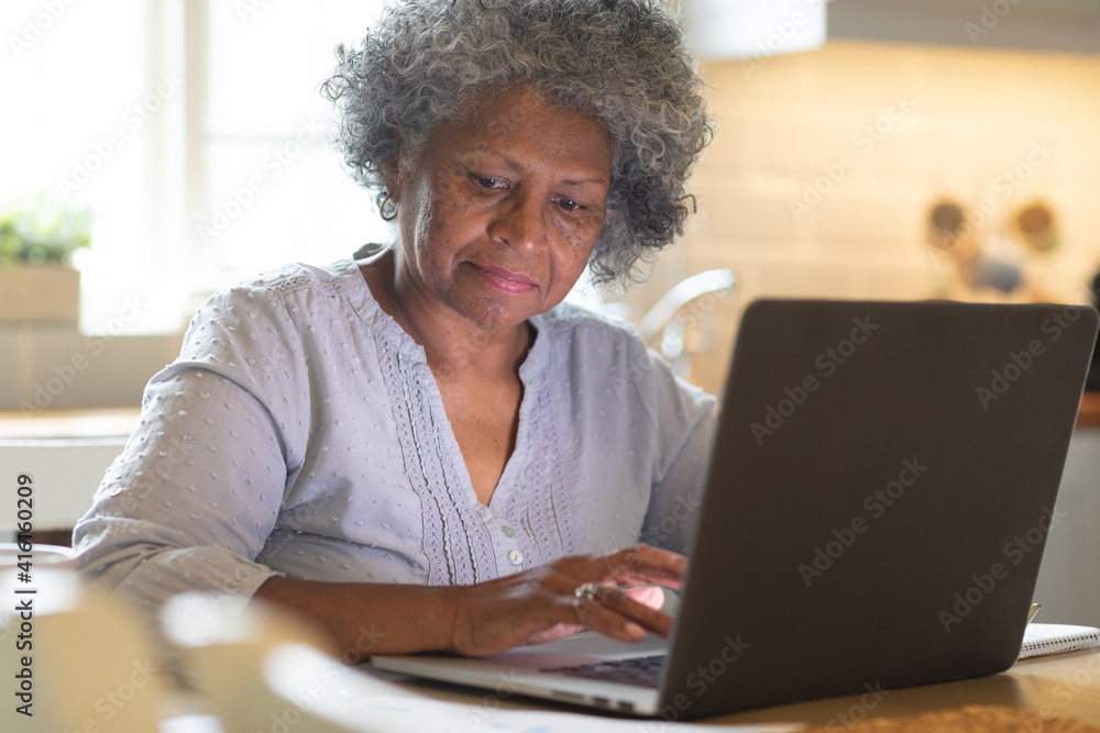 Thoughtful african american senior woman using laptop at home Thoughtful african american senior woman using laptop at home