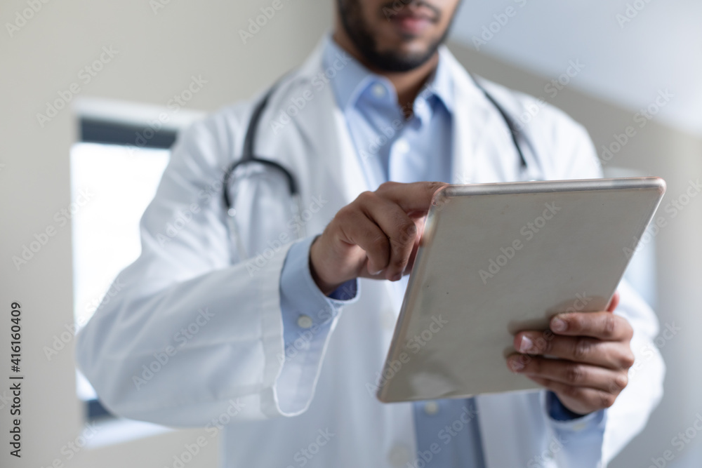 Mixed race male doctor using digital tablet computer Mixed race male doctor using digital tablet computer