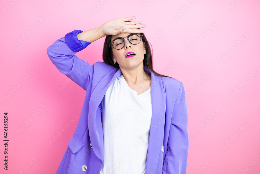 Young business woman wearing purple jacket over pink background Touching forehead for illness and fever, flu and cold, virus sick Young business woman wearing purple jacket over pink background Touching forehead for illness and fever, flu and cold, virus sick