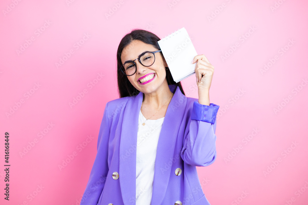 Φωτογραφία Young business woman wearing purple jacket over pink background smiling and show
