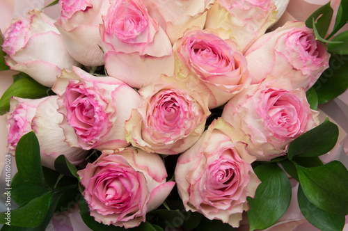 bouquet of pink white roses with leaves in packaging. mother's day, valentine's day, womens day