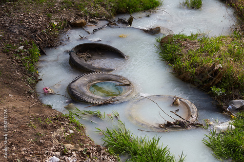 Fotografie Truck tires in the river water. Environmental pollution concept.