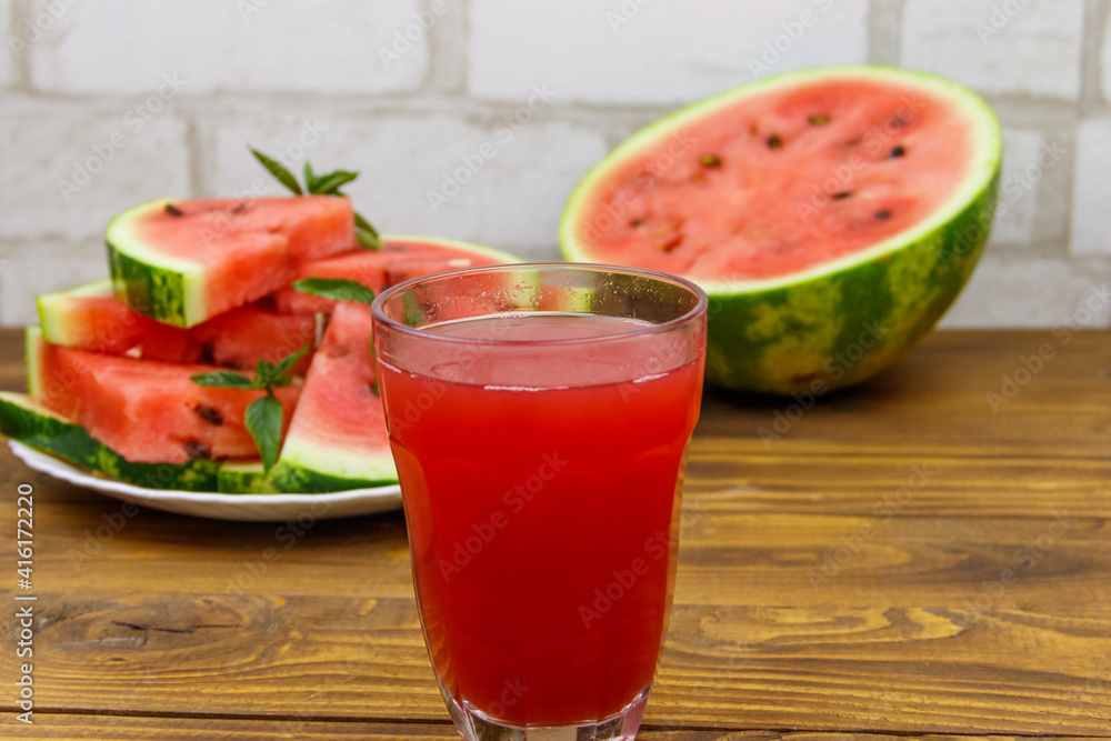 Glass of fresh watermelon juice on a wooden table Glass of fresh watermelon juice on a wooden table