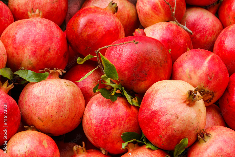 Heap of fresh pomegranates for sale in market. Background of pomegranate fruits Heap of fresh pomegranates for sale in market. Background of pomegranate fruits