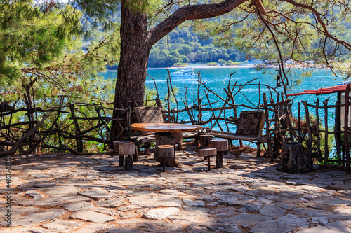 Empty rustic round wooden table and stools in park in Kemer, Turkey