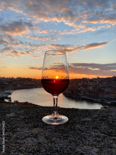 a glass of red wine on the Porto observation deck at sunset overlookin photo