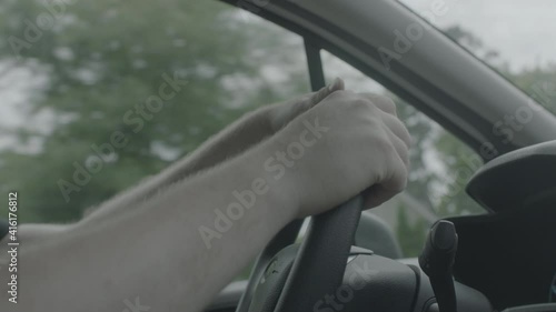 A man has his hands on the steering wheel photo