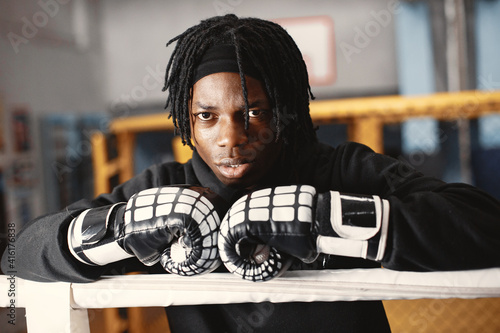 Sporty man boxing. Photo of boxer on a ring. African american man training. photo