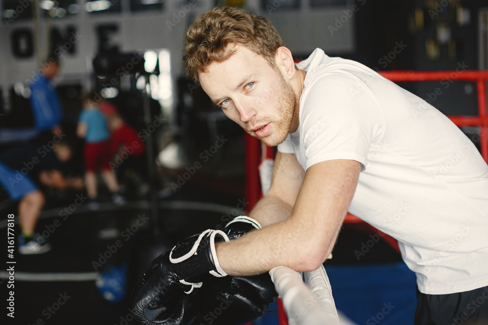 Sporty man boxing. Photo of boxer on a ring. Strength and motivation Sporty man boxing. Photo of boxer on a ring. Strength and motivation