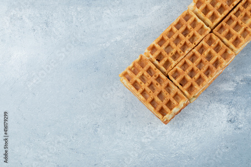 Delicious fresh waffles on a gray background