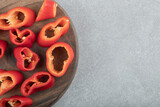 Slices of sweet red peppers on a wooden board