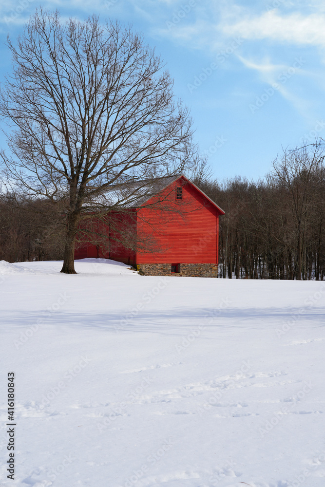 View of a traditional red barn in winter after a snowfall in New Jersey, United States
