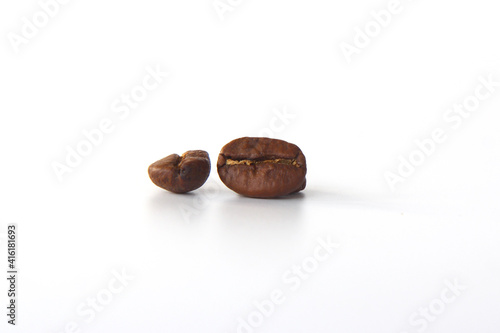 grain of aromatic black coffee on a white background. Background from two coffee beans, roasted coffee beans with selective focus close-up, place for text.
