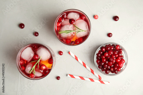 Tasty refreshing cranberry cocktail on light grey table  flat lay