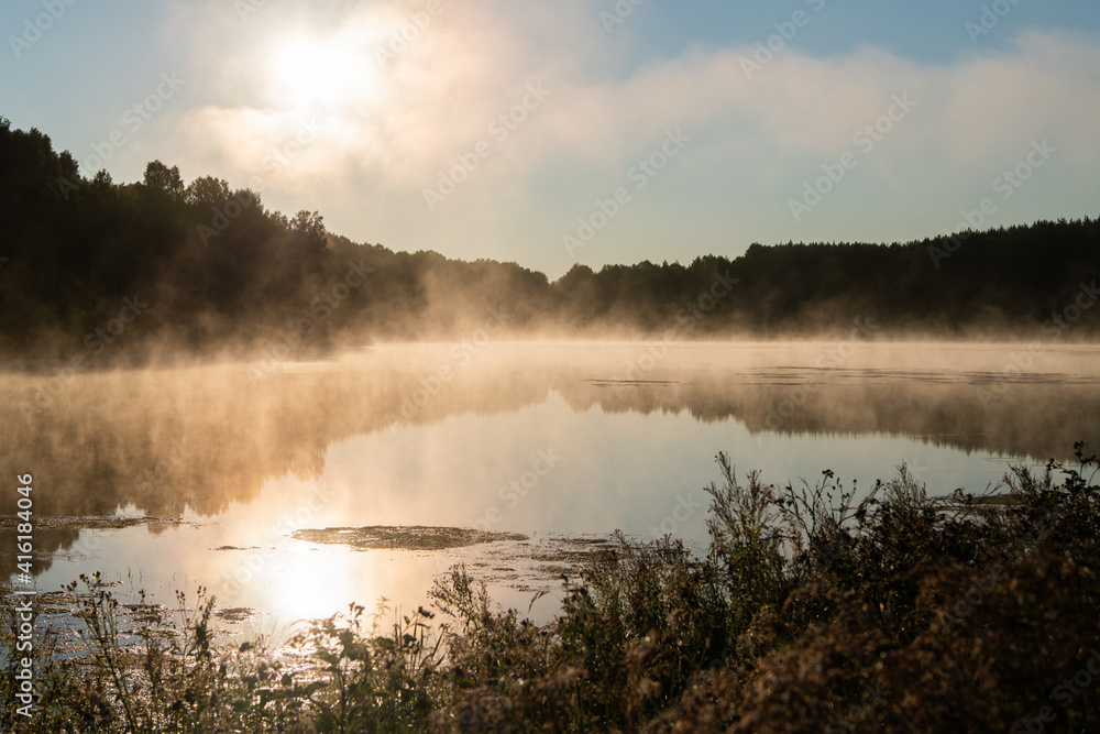 Sunrise and mist on a beautiful lake in the early morning.