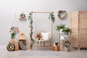 Easter photo zone with floral decor and swing chair indoors