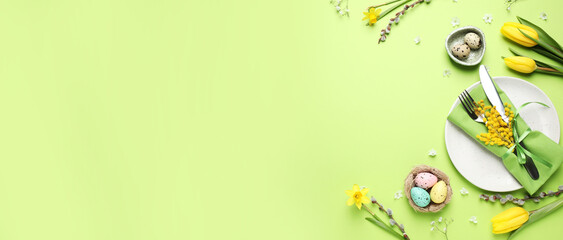 Festive Easter table setting with eggs and floral decor on green background, flat lay. Space for text