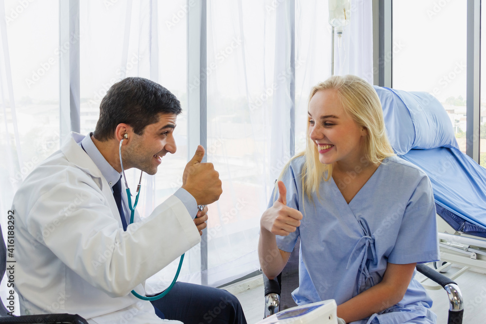 Obraz premium male doctor talked to a female patient with a thumbs up about the improvement of his condition
