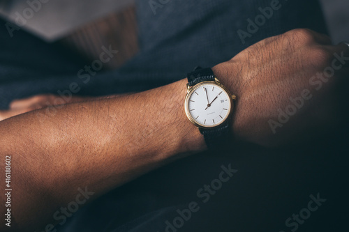 fashionable wearing stylish looking at luxury watch on hand check the time at workplace.concept for managing time organization working,punctuality,appointment.