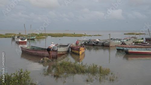 Fisherman preparing fishing boats in marshland  photo