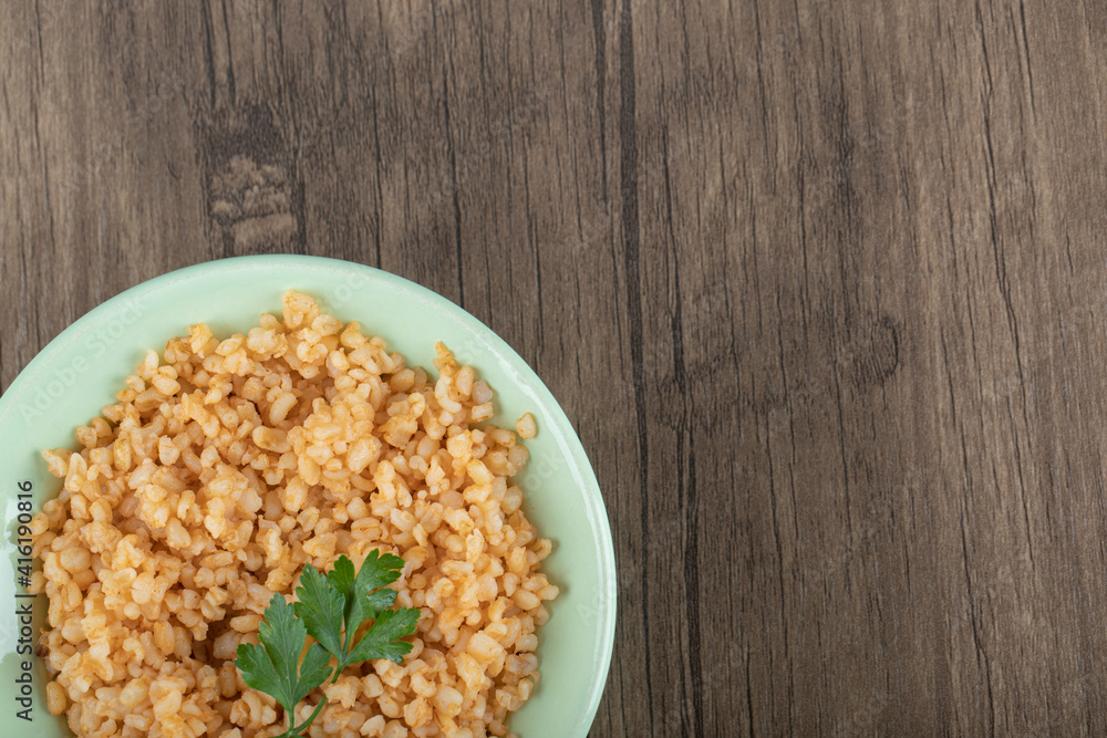 Delicious bulgur with greens on a green plate Delicious bulgur with greens on a green plate