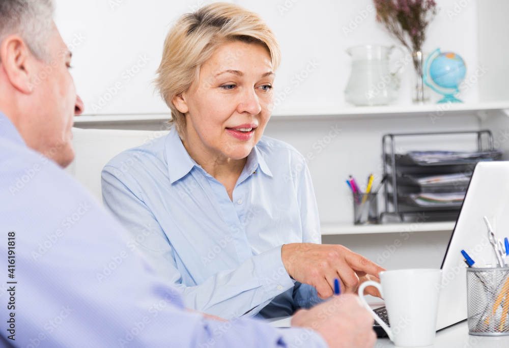 Fototapeta premium Male and female business partners discussing documents deal