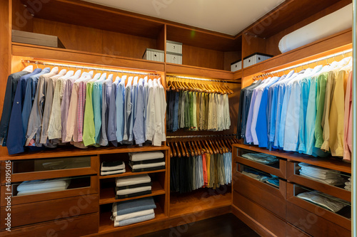 Large luxury men's wardrobe with different clothes.