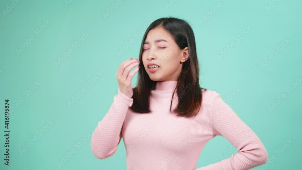Close up portrait young Asian beautiful woman bored yawning tired covering mouth with hand. Female sleepy restless and sleepiness isolated on blue background
