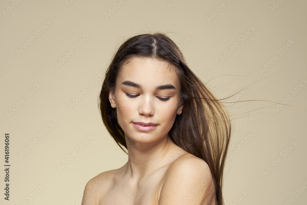 Pretty woman naked shoulders long hair body care beige background Pretty woman naked shoulders long hair body care beige background