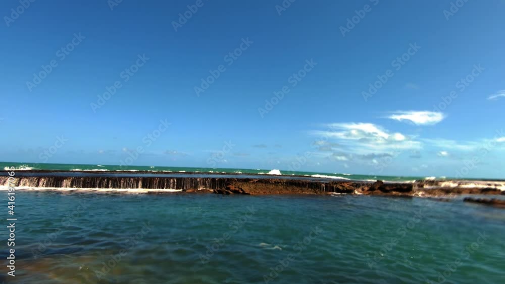 Beautiful tilt up shot of a natural waterfall in the ocean created low tide in the small beach town of Sibauma near Pipa in Rio Grande do Norte, Brazil. Beautiful tilt up shot of a natural waterfall in the ocean created low tide in the small beach town of Sibauma near Pipa in Rio Grande do Norte, Brazil.