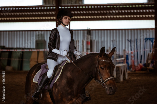 Young woman is engaged in equestrian sports, training on horseback