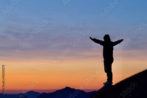 silhouette of a person on the hill to look sunrise.