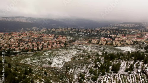 Jerusalem red rooftops and traffic in the snow aerial view
,drone view over mevasert zion close to Jerusalem covered with snow, February 2021
 photo