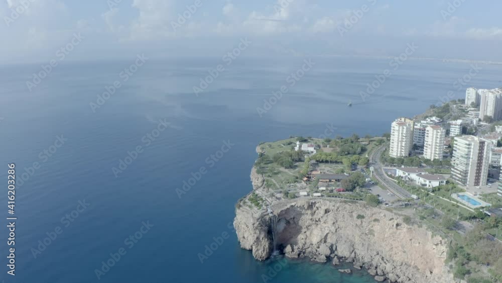 Drone video of the Sera-Enomor landscape. The rocky shoreline is washed by the waves of the sea. City with houses and streets and on a background of mountains. Aerial view Antalya Turkey. Drone video of the Sera-Enomor landscape. The rocky shoreline is washed by the waves of the sea. City with houses and streets and on a background of mountains. Aerial view Antalya Turkey.