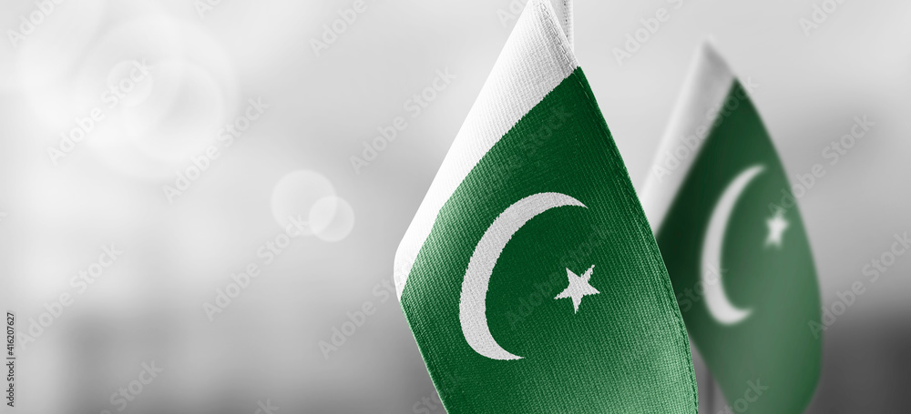 Small national flags of the Pakistan on a light blurry background - obrazy, fototapety, plakaty 