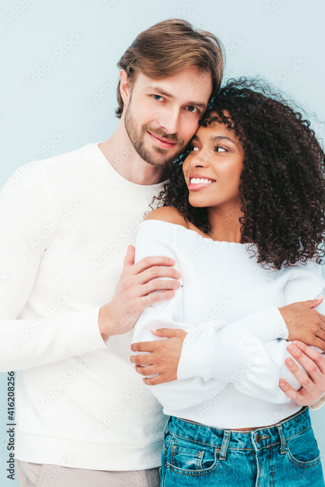 Smiling beautiful woman and her handsome boyfriend. Happy cheerful multiracial family having tender moments on grey background in studio. Multiethnic models hugging. Embracing each other.Love concept Smiling beautiful woman and her handsome boyfriend. Happy cheerful multiracial family having tender moments on grey background in studio. Multiethnic models hugging. Embracing each other.Love concept