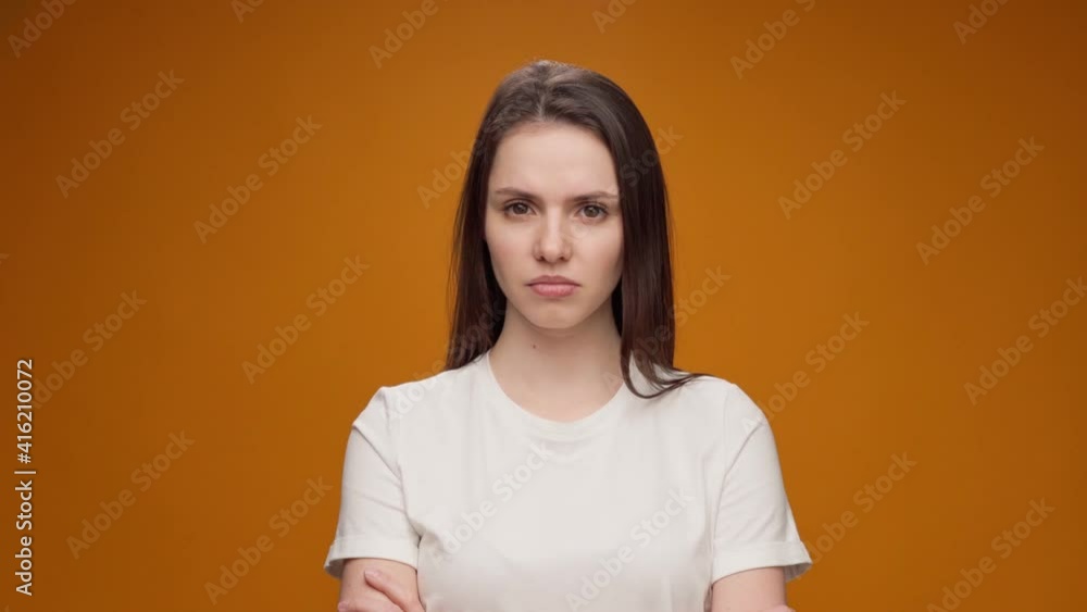 Young woman expressing aversion, rejection, negative attitude against yellow background Young woman expressing aversion, rejection, negative attitude against yellow background