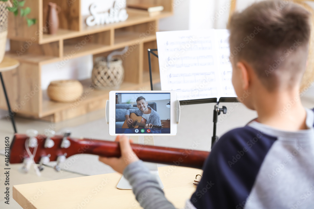 Little boy taking music lessons online at home Little boy taking music lessons online at home