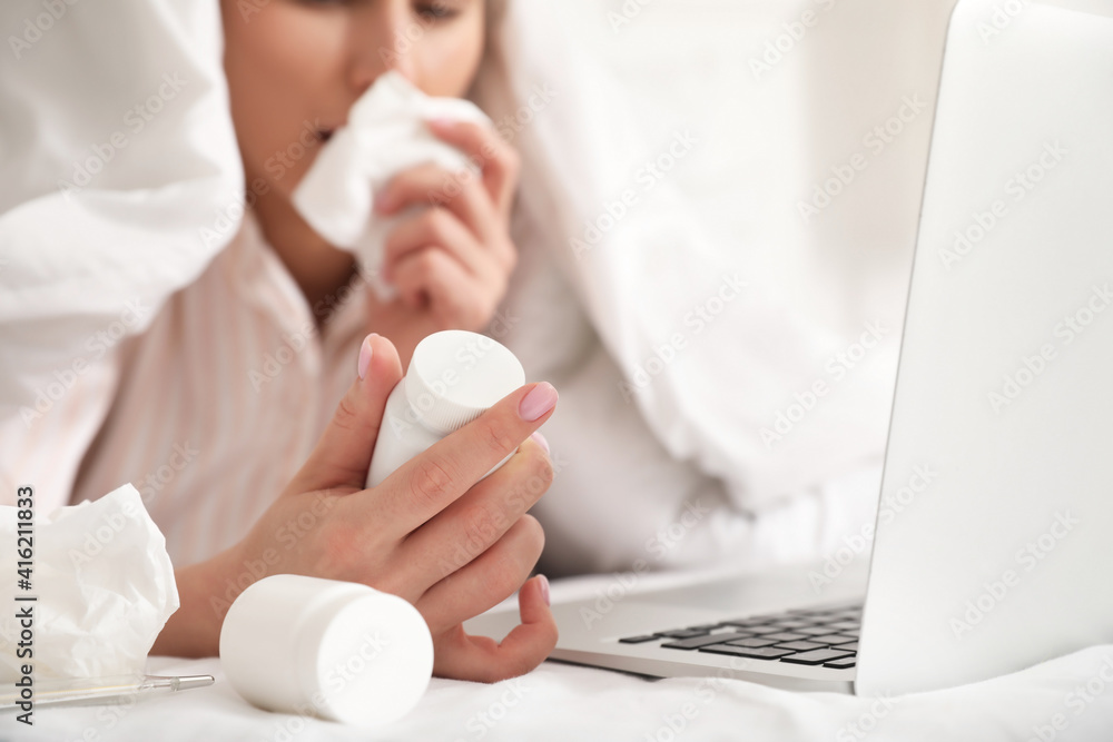 Sick young woman with laptop working at home Sick young woman with laptop working at home