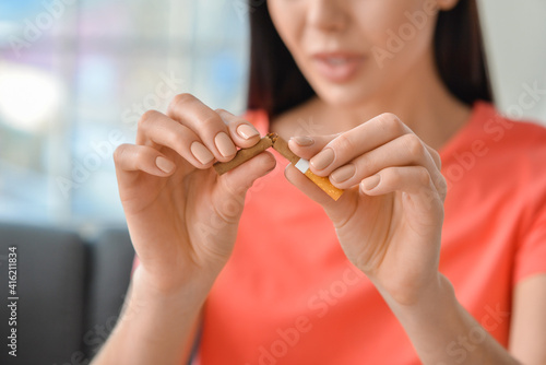 Young woman breaking cigare...