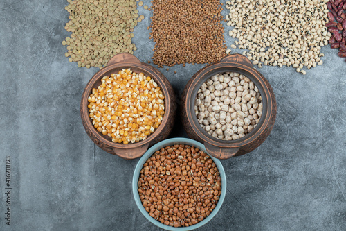 Different kinds of raw beans on a gray background
