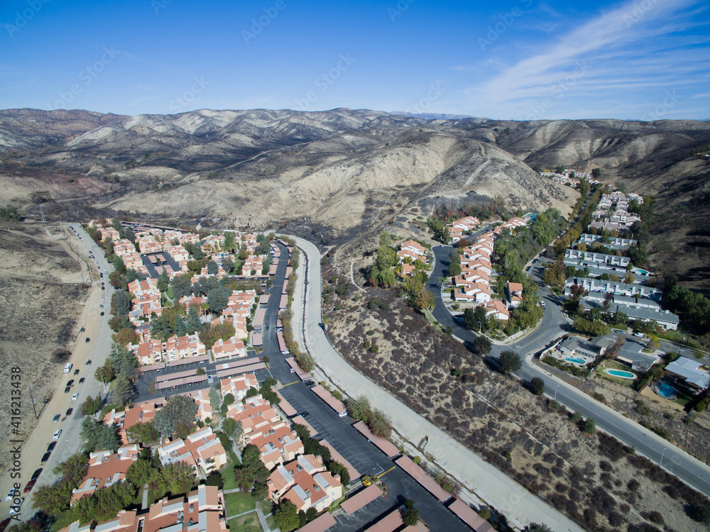 A charred hillside where a wildfire was stopped short of a neighborhood below