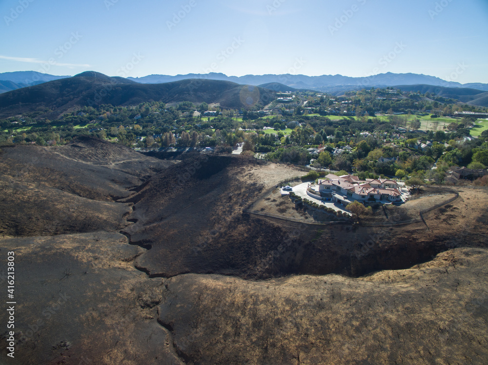 A lone house sits atop a charred hillside where a wildfire destroyed everything else A lone house sits atop a charred hillside where a wildfire destroyed everything else