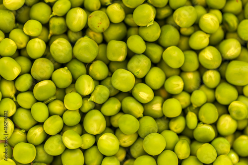 A scattering of fresh green peas from above, background © evgenii