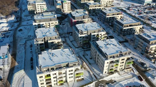 Zlicin, suburbia of Prague, Czech Republic. Aerial view of snow capped buildings in residential neighborhood on sunny winter day, drone shot photo